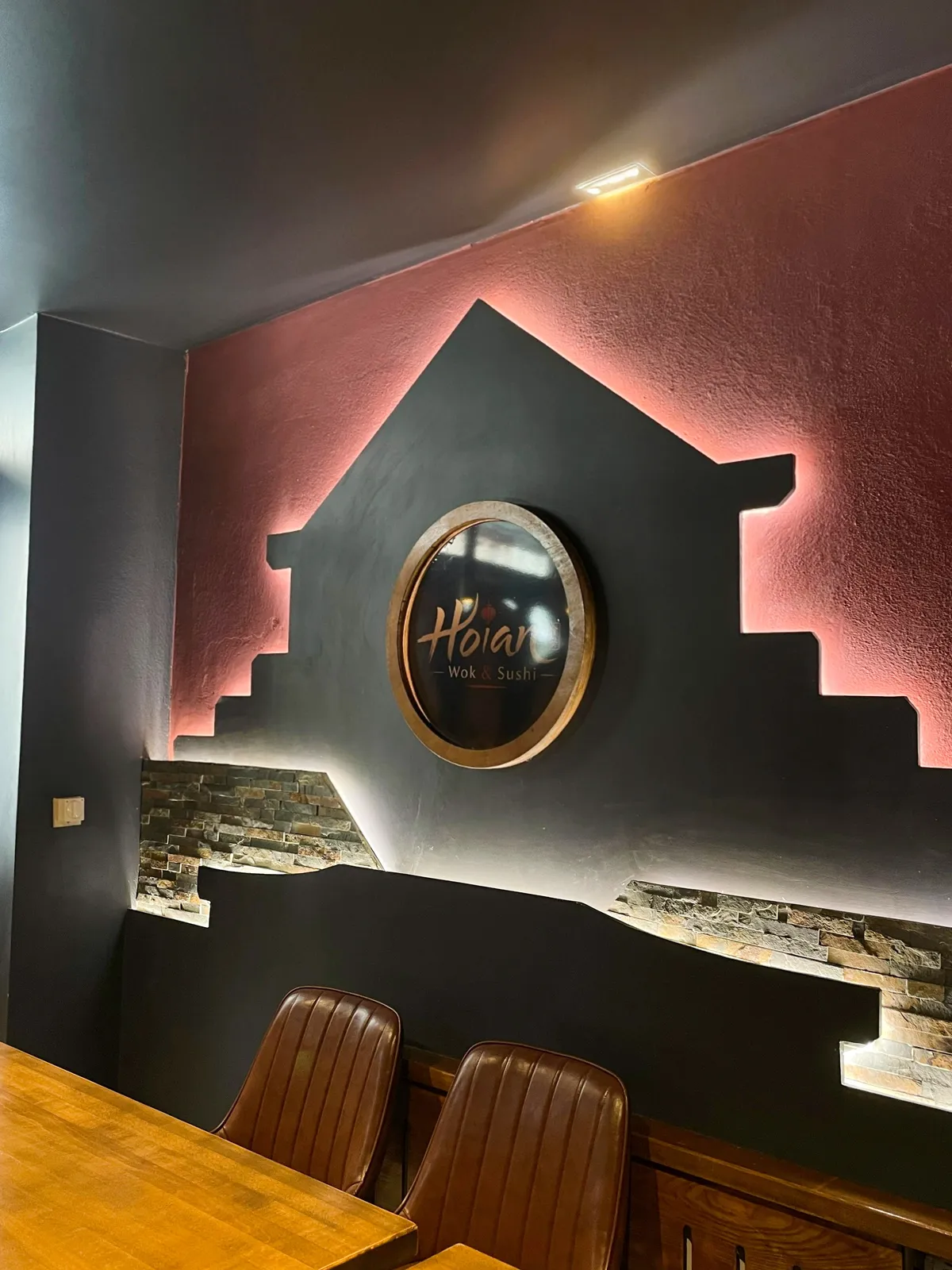 Wandbild mit dem Schriftzug des Restaurants über den Sitzplätzen