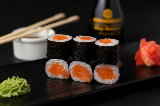 Maki mit Lachs, dazu Wasabi und eingelegter Ingwer
